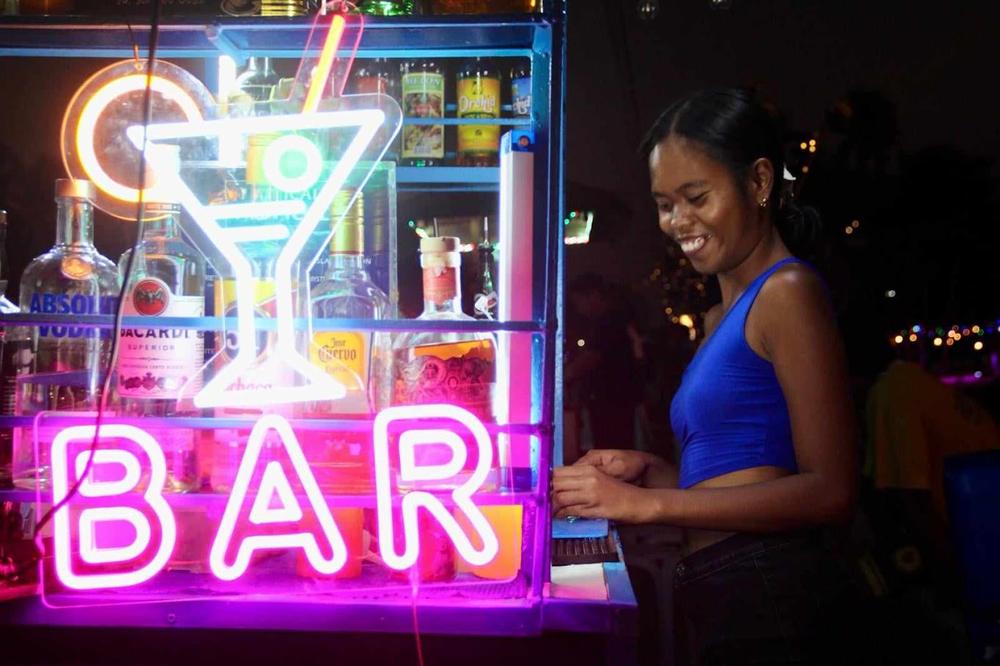 The neon-lit bar counter with the team at work