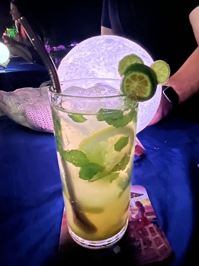 Mystical Blue cocktail served beside a moon lamp on a blue table